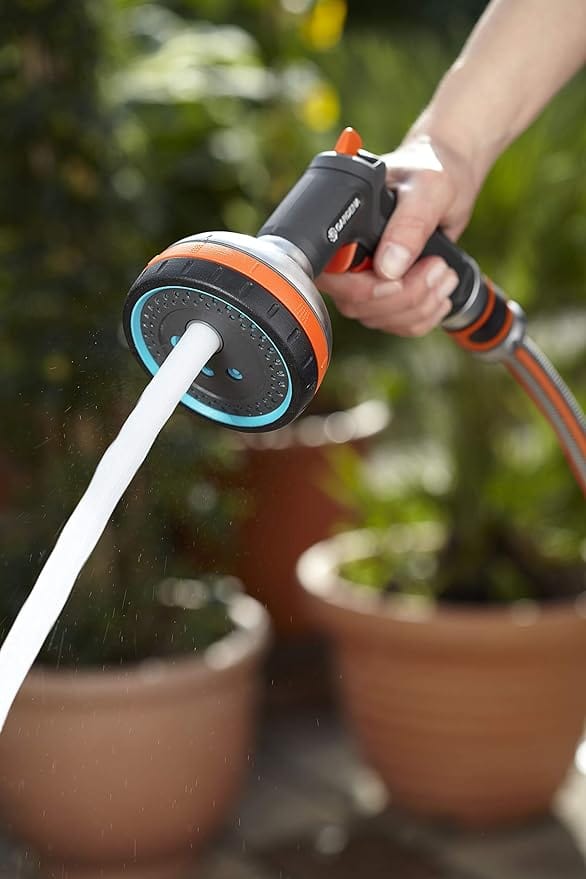 Gardena multi sprayer sending a jet of water into a clay pot