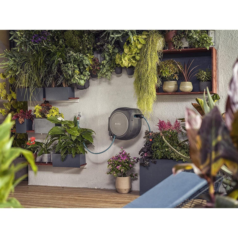 Gardena RollUp reel on a wall in a planted courtyard