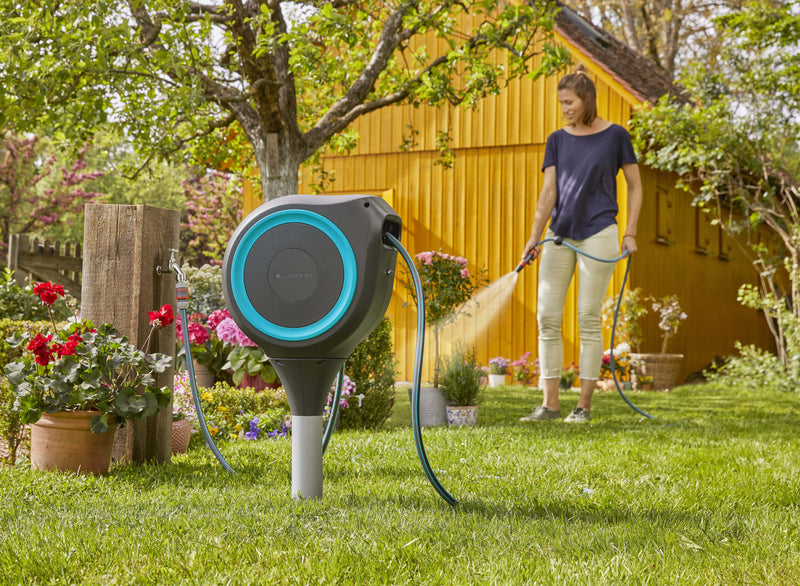 Gardener watering beds with hose from the Gardena RollUp S