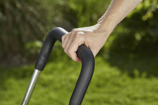 Hand on the folding handle of the Gardena hose trolley