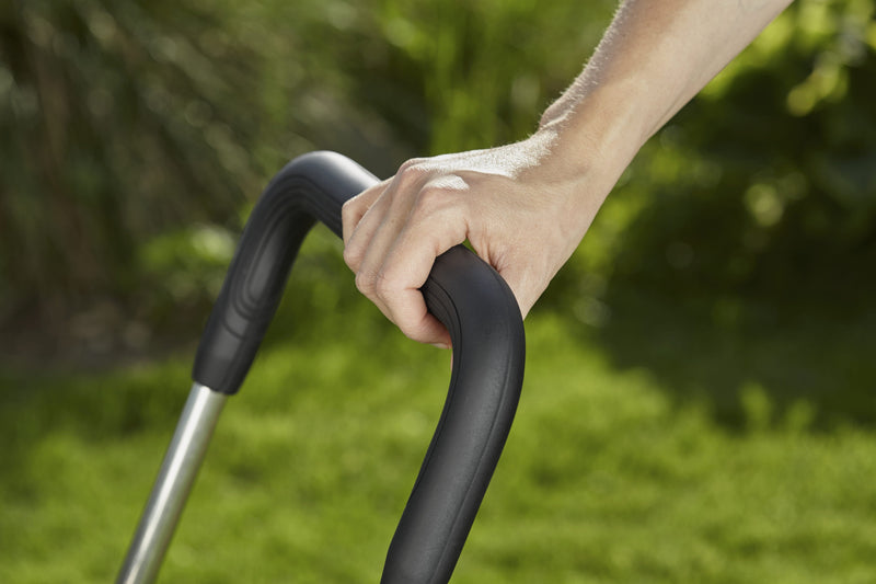 Hand on the folding handle of the Gardena hose trolley
