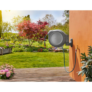 Gardena RollUp reel mounted on an orange wall beside a garden