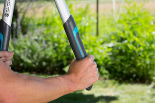 Hand on the extended handle of the Gardena TeleCut lopper