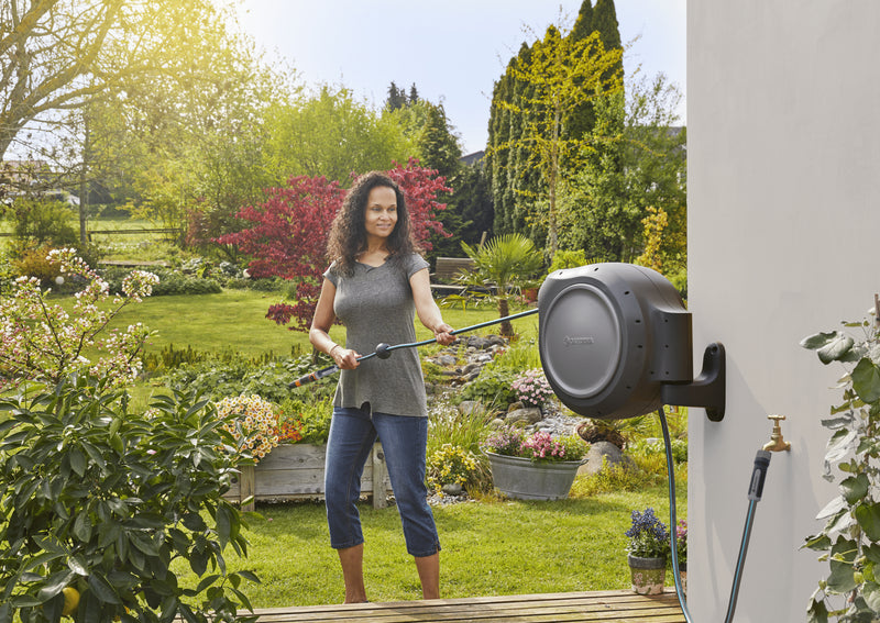 Gardener walking out with hose from the Gardena RollUp reel
