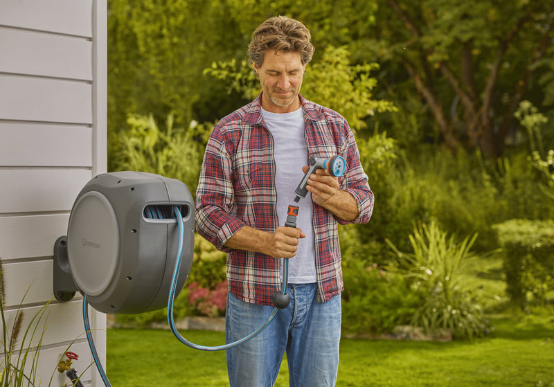 Gardener checking the spray nozzle next to the Gardena reel
