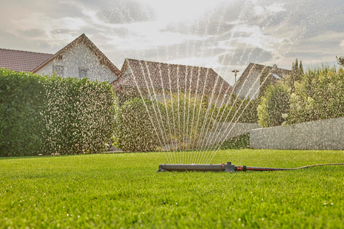 Gardena AquaZoom sprinkler watering a large lawn beside houses