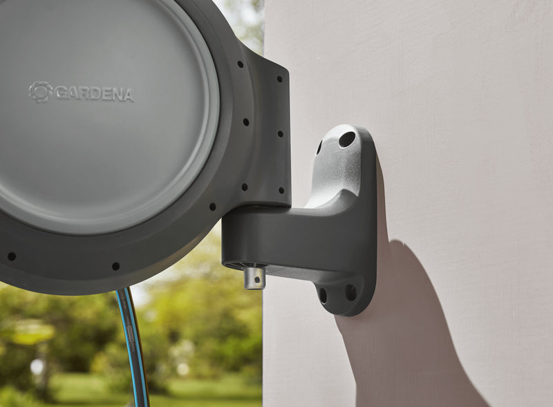 Hand fitting the Gardena RollUp reel onto its wall bracket
