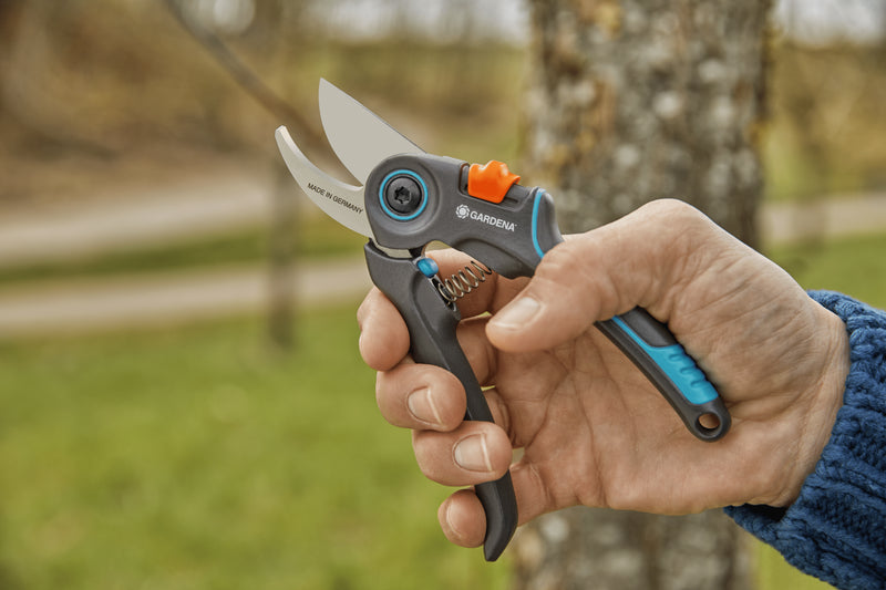 Hand holding the Gardena ExpertCut shears open outdoors